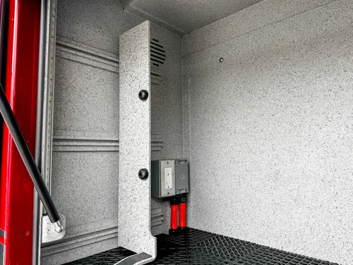 Open side fill-port door close-up with circular intake opening.